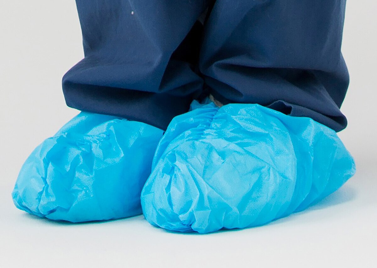 Close-up of blue 16-inch non-sterile disposable shoe covers worn over footwear