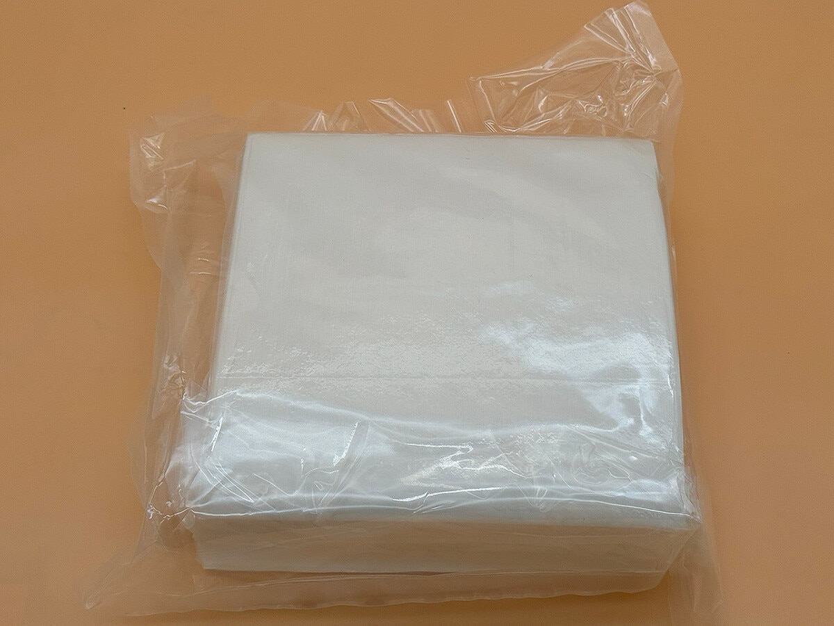 Top view of AstroWipe cleanroom wipes with smooth white wipe surface visible through packaging