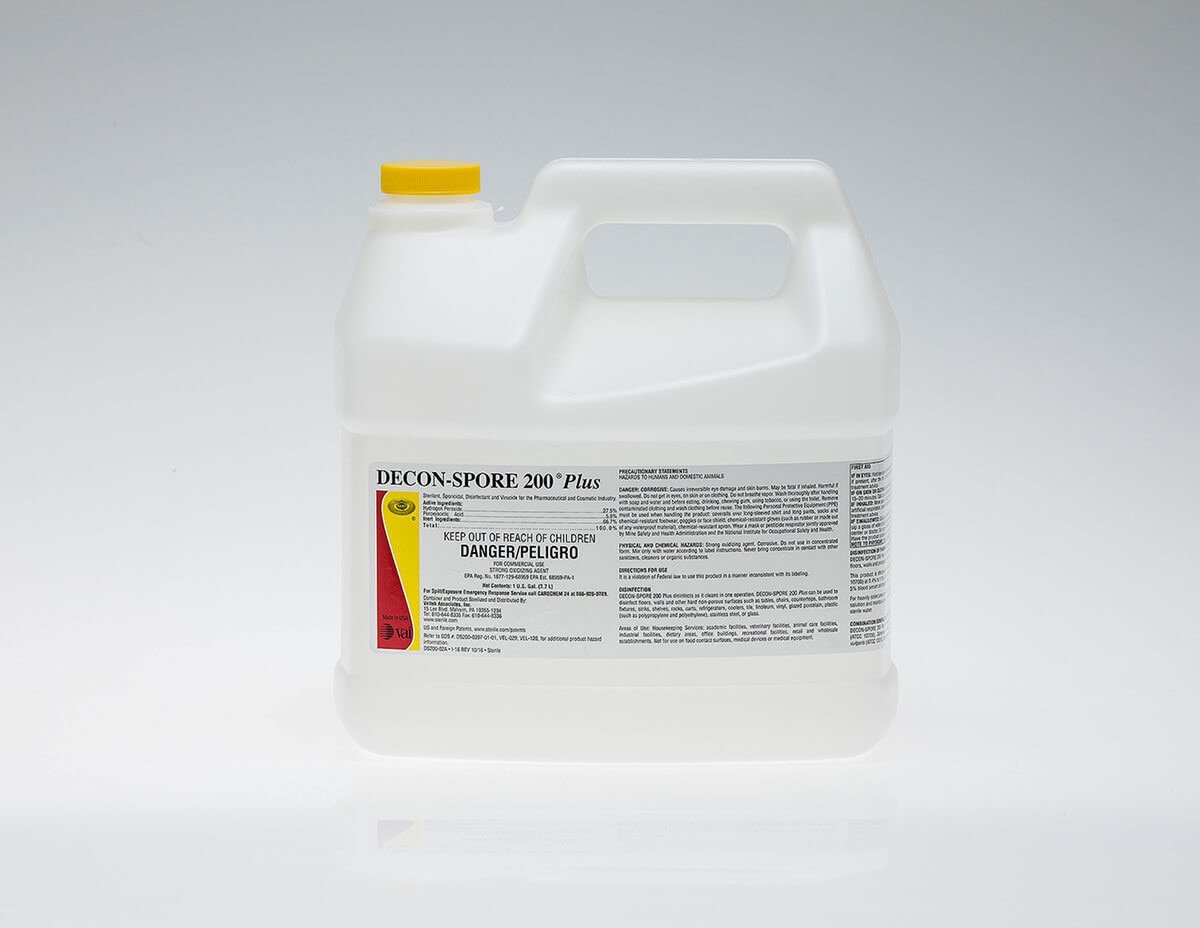 DECON-SPORE 200 Plus 1-gallon concentrate container with yellow cap, displayed on a clean white reflective surface with the product label facing forward.