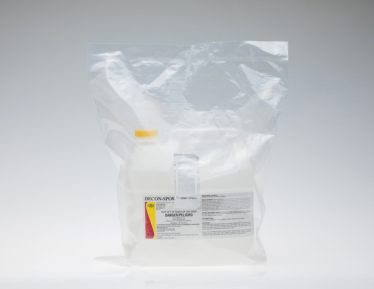 DECON-SPORE 200 Plus 1-gallon concentrate container sealed inside a clear sterile poly bag, shown upright on a white reflective surface.