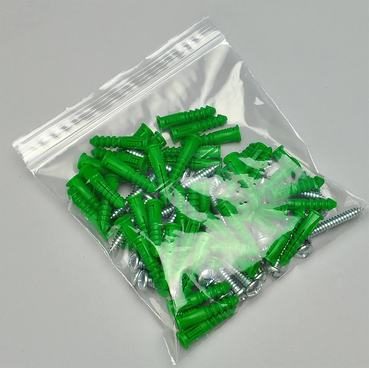 LK clear 2 mil single-track reclosable zipper bag holding green wall anchors and metal screws